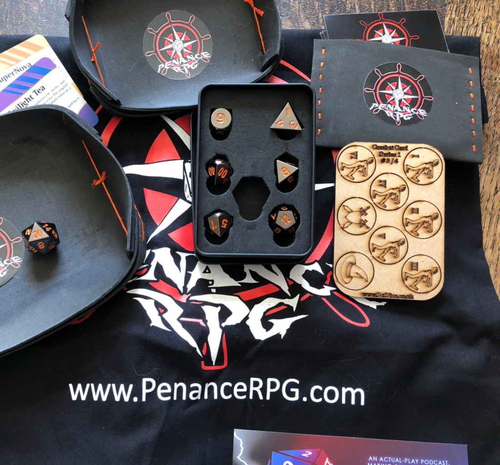 Penance RPG prize, mainly black items with red logos or orange detailing to match the shiny black metal dice with orange numbers. Includes a bag and two dice trays